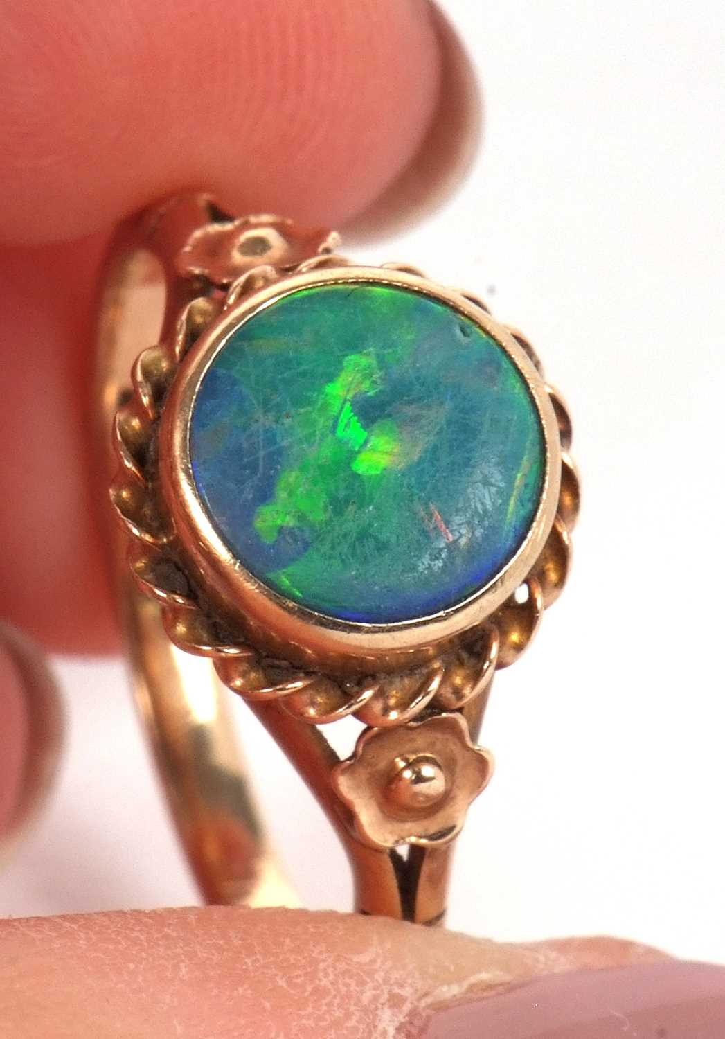 A 9ct opal ring,the round opal cabochon, collet mounted with rope twist border and closed back, 10. - Image 3 of 11