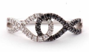An 18ct white gold, black and white diamond ring, the two strand crossover style band set on half