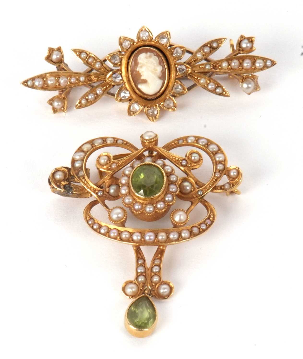 Two gemset brooches, the first an Art Nouveau peridot and seed pearl brooch/pendant, 32mm wide,