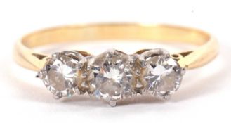 An 18ct and platinum three stone diamond ring, the three round brilliant cut diamonds, total