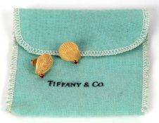 A pair of 14k Tiffany and ruby shell earrings, the naturalistic shells, each set with a small
