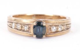 A 9ct topaz and diamond ring, the oval topaz in a four claw mount and set to either side with