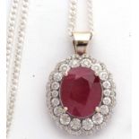 An 18ct ruby and diamond cluster pendant, the oval ruby, approx. 14 x 10.8 x7.6mm, in a four claw