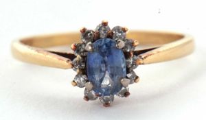 An 18ct sapphire and diamond ring, the oval pale blue sapphire in a four claw mount, surrounded by