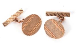 A pair of 9ct cufflinks, the oval discs with textured design, stamped to reverse '9.375', with chain