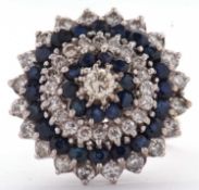 A diamond and sapphire cluster ring, the central round brilliant cut diamond surrounded by four