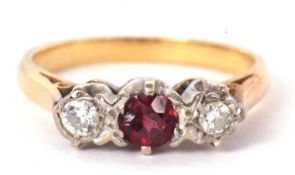 A three stone ruby and diamond ring, the central round ruby set to either side with an illusion