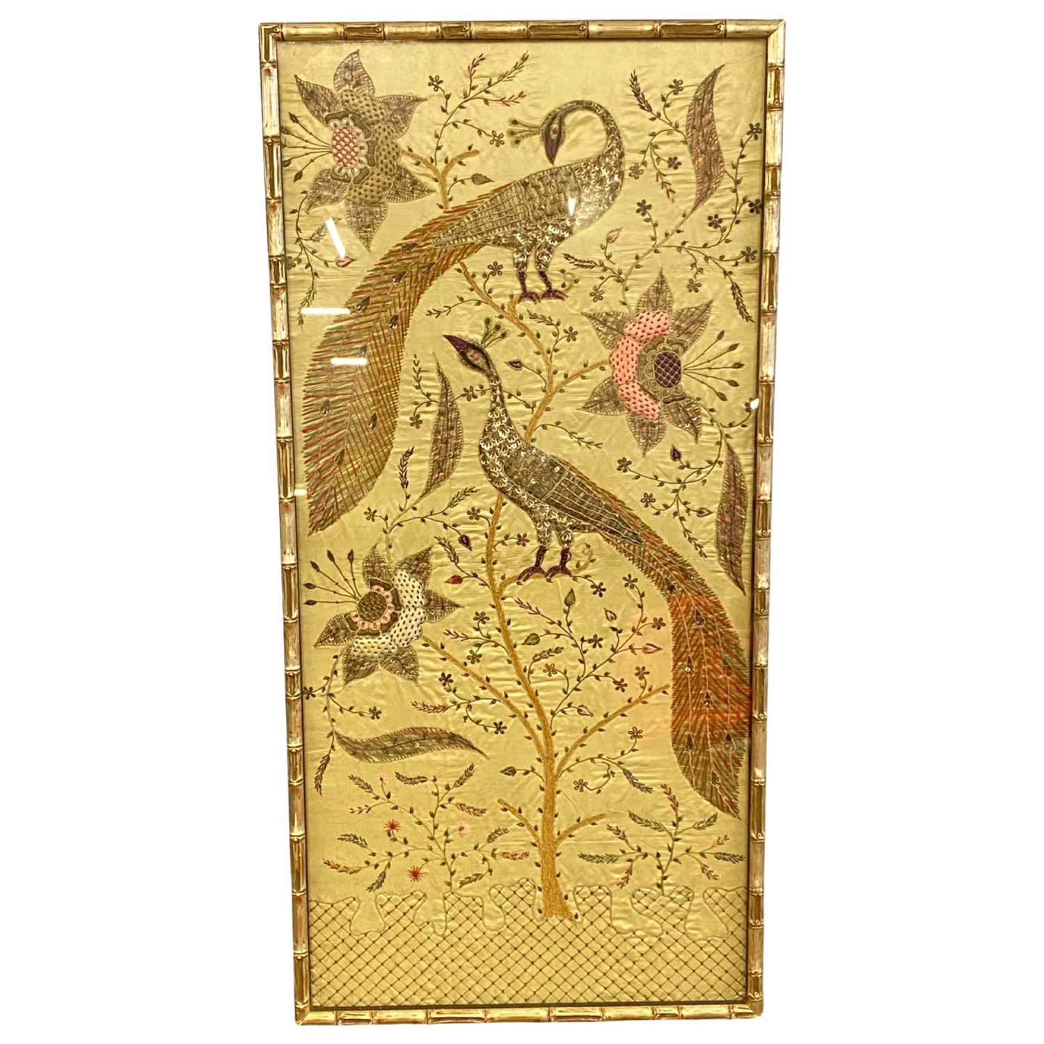 An Indian embroidered silk picture, on cream silk embroidered with peacocks, flowers and foliage, in