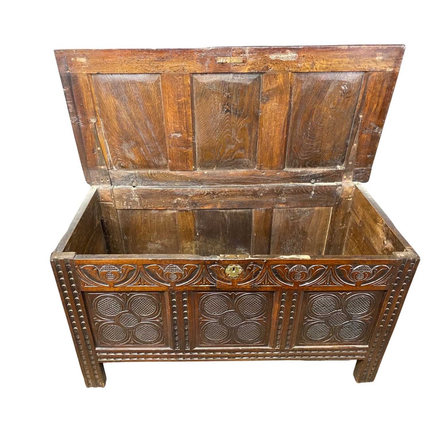 18th Century oak coffer with panelled lid over a carved three panelled front raised on style feet, - Image 3 of 4