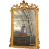 Large gilt framed over mantel mirror of rectangular form, the frame decorated with a large applied