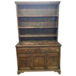 Georgian oak dresser with shelved back over a base with two drawers and two panelled doors raised on