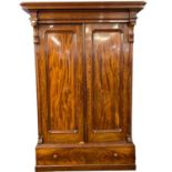 A large Victorian mahogany wardrobe with architectural cornice over two panelled doors and a base,