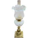 A late 19th or early 20th Century oil lamp with frosted frilled glass shade, marbled glass font