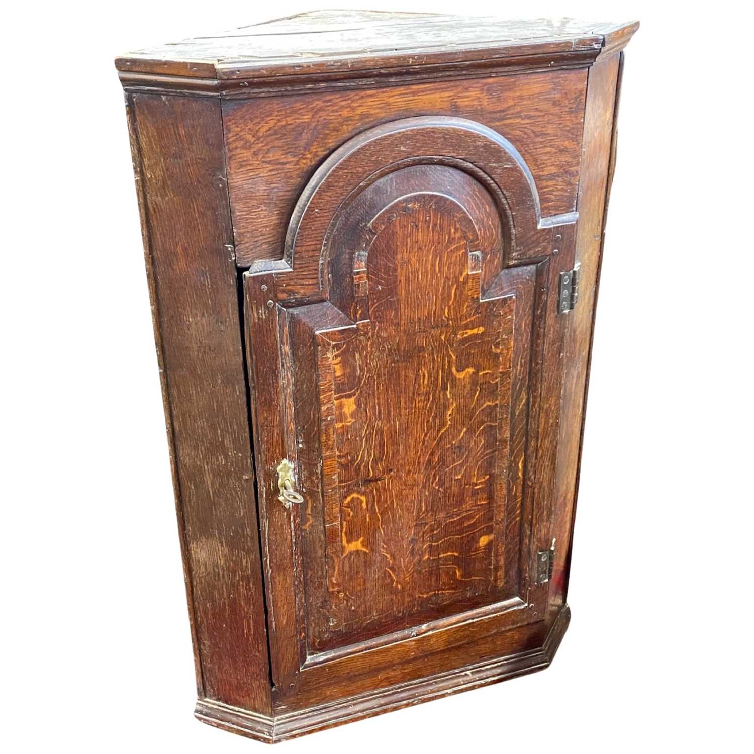 18th Century oak corner cabinet with arched panelled door opening to a shelved interior, 100cm high