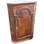 18th Century oak corner cabinet with arched panelled door opening to a shelved interior, 100cm high