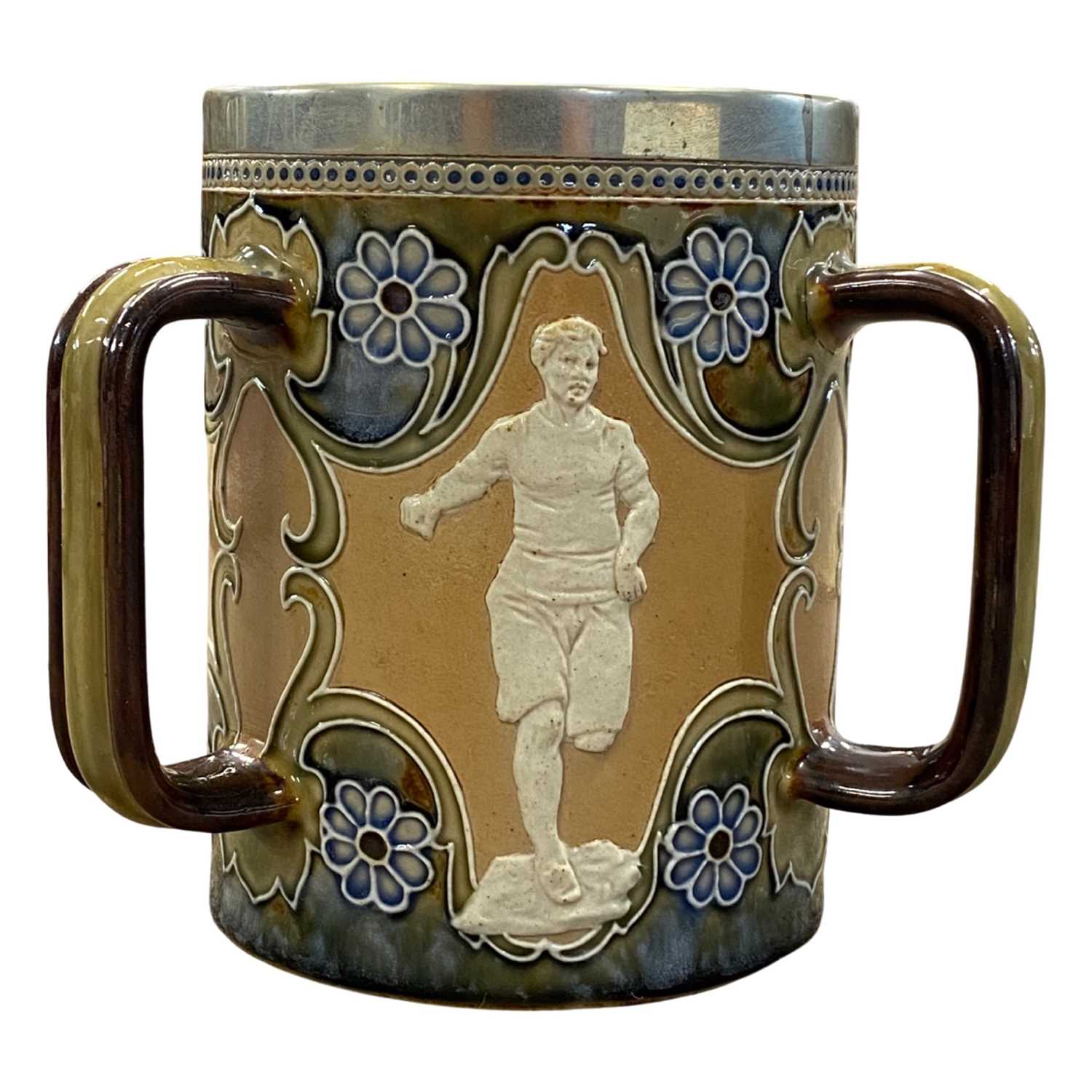 Doulton Lambeth stone ware tyg decorated with panels of atheletes fitted with a silver plated rim,