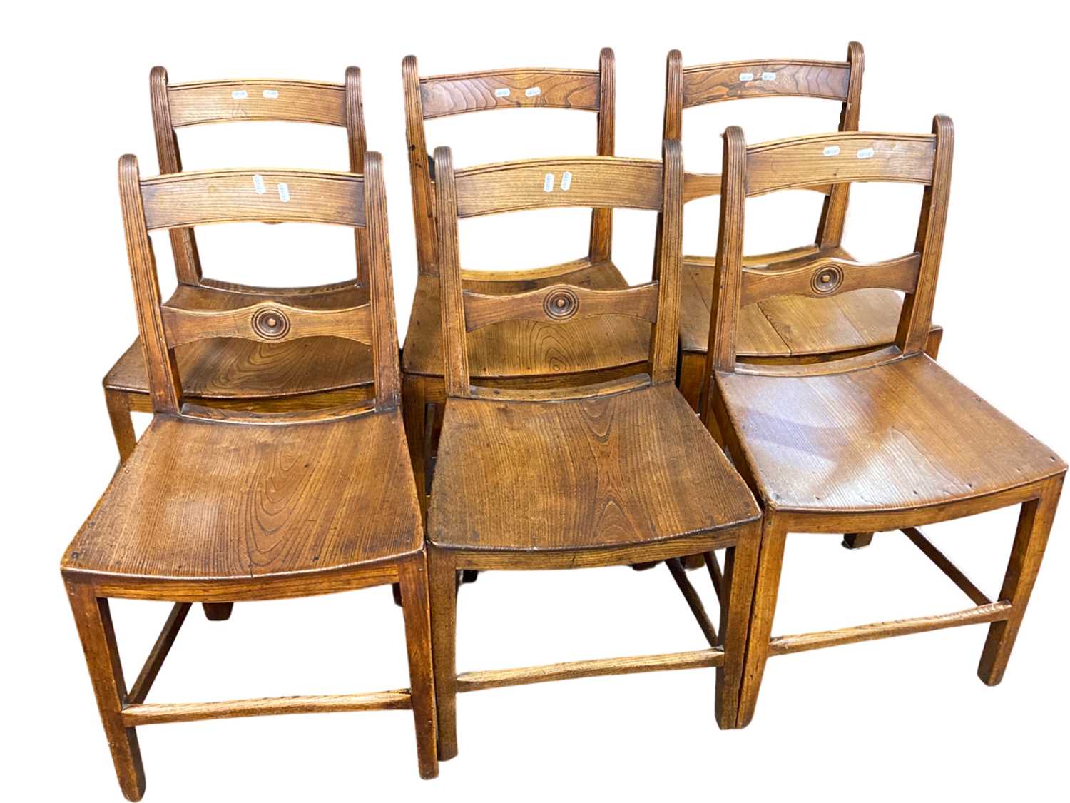 A set of six East Anglian 19th Century elm seated dining chairs, the backs with target type