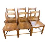 A set of six East Anglian 19th Century elm seated dining chairs, the backs with target type