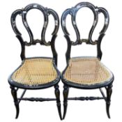 A pair of Victorian black lacquered papier mache and mother of pear inlaid side chairs with cane