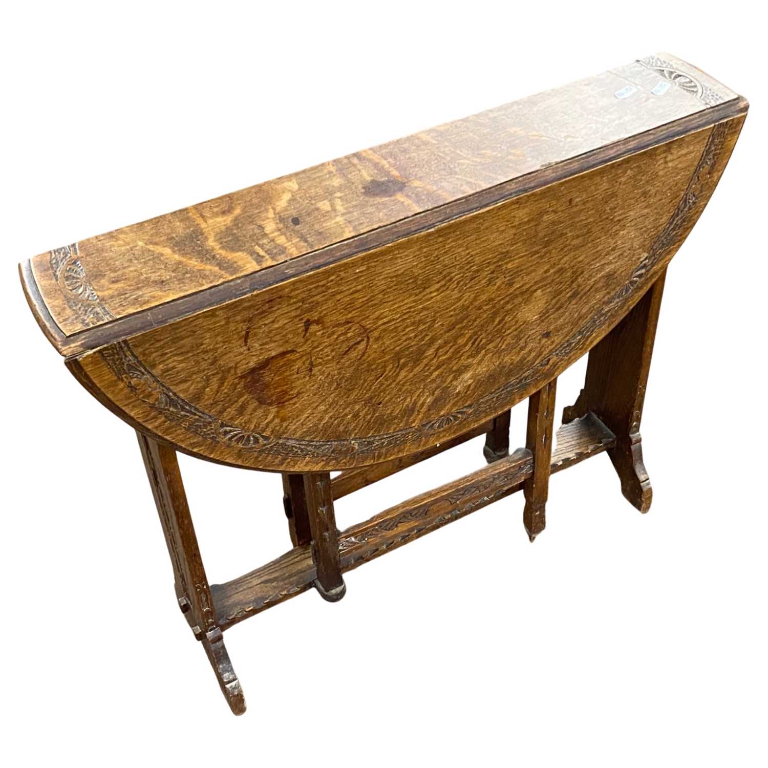 A late 19th Century Arts & Crafts style oak drop leaf occasional table of oval form with pierced