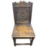 Hard seated hall chair in the 18th Century style with a floral carved panelled back, turned front