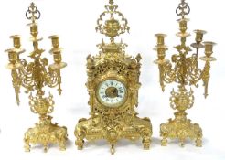 20th Century continental ornate three piece brass clock garniture comprising a clock with white