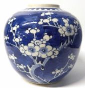 A Chinese porcelain ginger jar decorated with prunus on a blue ground