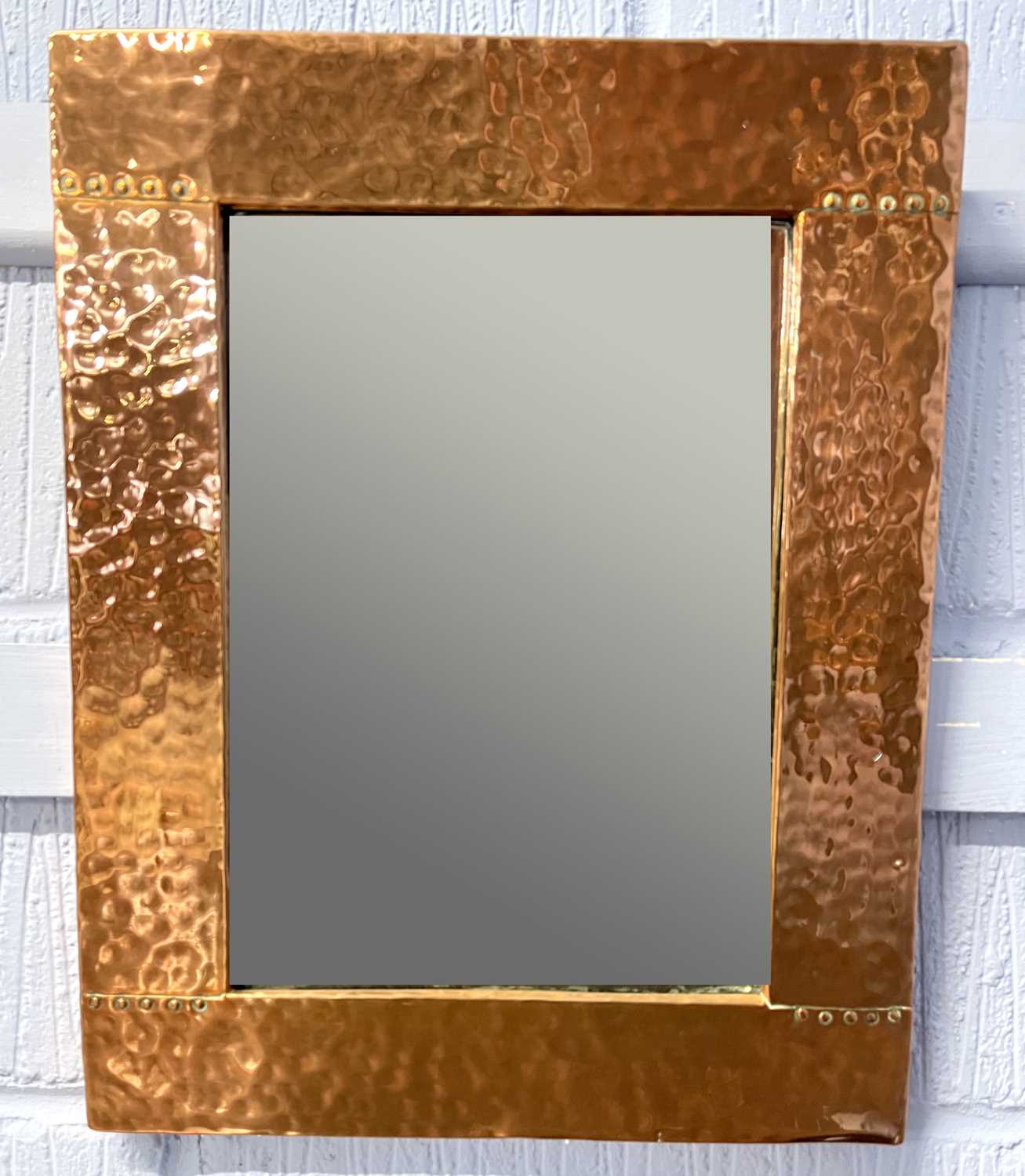 An Arts & Crafts style rectangular wall mirror in planished copper frame, 37 x 47cm - apparently
