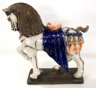 A large ceramic model of a prancing horse on rectangular base, 40cm high
