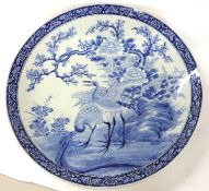 A very large Japanese porcelain charger, late Meiji period decorated in blue and white with wading