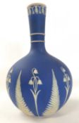 A 19th Century Wedgwood type globular vase, the blue ground decorated with lilies and the base