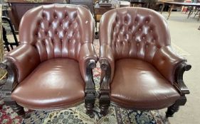 A pair of late 19th Century buttoned leather upholstered armchairs with showwood arms with carved
