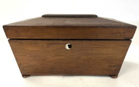 A 19th Century rosewood sarcophagus formed tea caddy with sub-divided interior raised on bun feet,