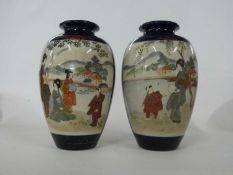 Pair of Japanese Satsuma ware vases, the blue ground with panels of Japanese figures in landscape