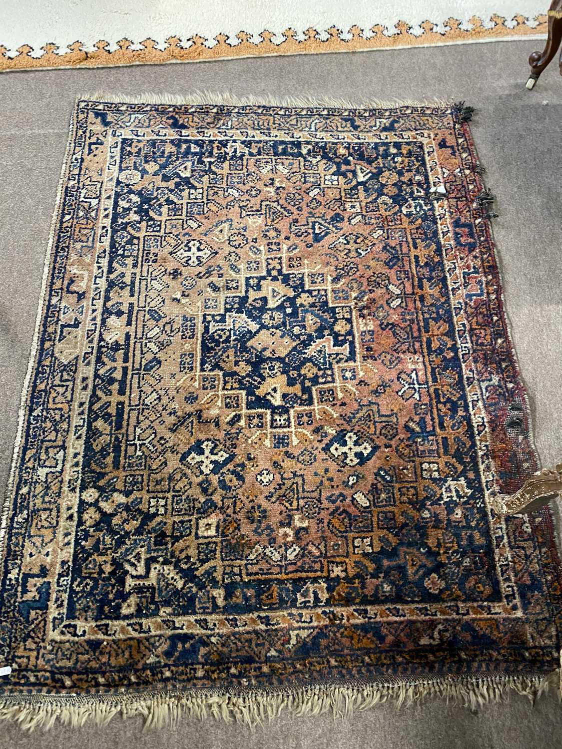 Small antique Middle Eastern wool floor rug decorated with a large central lozenge on a