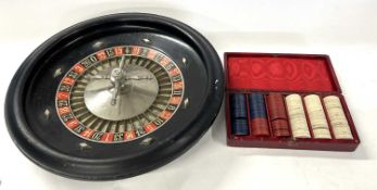 A French roulette wheel bearing makers name Aculette together with a red leather case of gaming