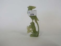 Jade model of a bird on a rock with carved flowers beneath, 12cm high