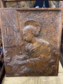 20th Century carved oak panel depicting a lady playing a piano, initialled 'AW' to the reverse, 37 x