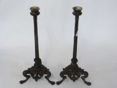 Pair of bronzed metal Art Nouveau style candlesticks, the columns raised on three scroll feet,