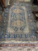 Antique Middle Eastern wool floor rug decorated with large central blue panel with geometric