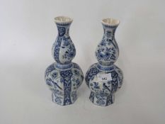 A pair of Dutch Delft vases of faceted form decorated with flowers and birds, 26cm high