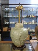 Large Chinese porcelain lamp with celadon glaze decorated in relief with flower heads on a shaped