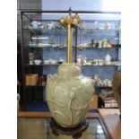 Large Chinese porcelain lamp with celadon glaze decorated in relief with flower heads on a shaped