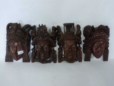 Group of four wooden carved masks, probably Balinese of various deity's