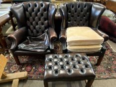 Pair of leather Chesterfield style wing back chairs and accompanying stool, the chairs 95cm high -