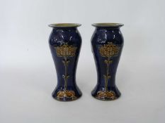 Pair of Royal Doulton Art Nouveau vases, the blue ground with Art Nouveau style flower heads, 19cm