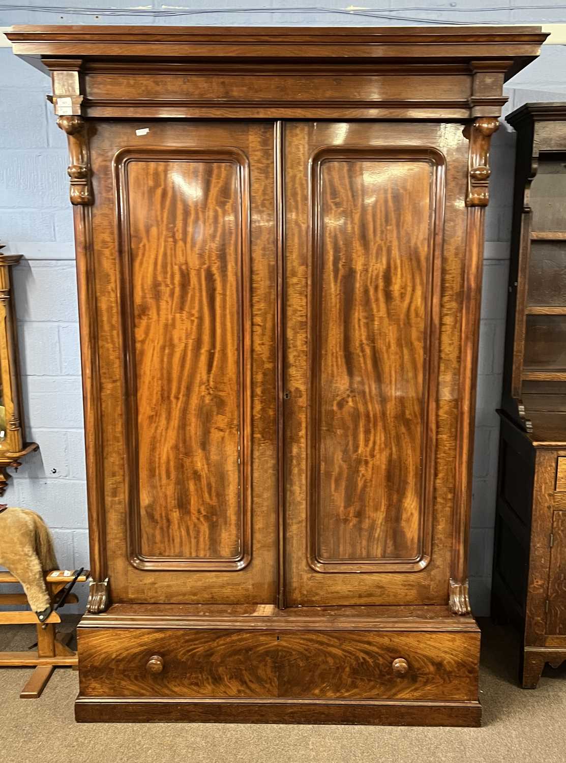A large Victorian mahogany wardrobe with architectural cornice over two panelled doors and a base,