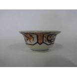 Japanese porcelain bowl of flared form decorated in Imari style with panels of dragons chasing the