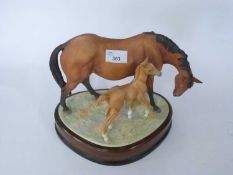 Royal Worcester figure of a horse and foal by Doris Linder on shaped wooden base