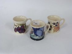 Three Moorcroft pottery tankards including one marked MCC 1992 and two further tankards decorated